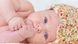 Маленький младенец смотрит голубыми глазками