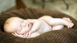 Спящий голенький ребенок младенец